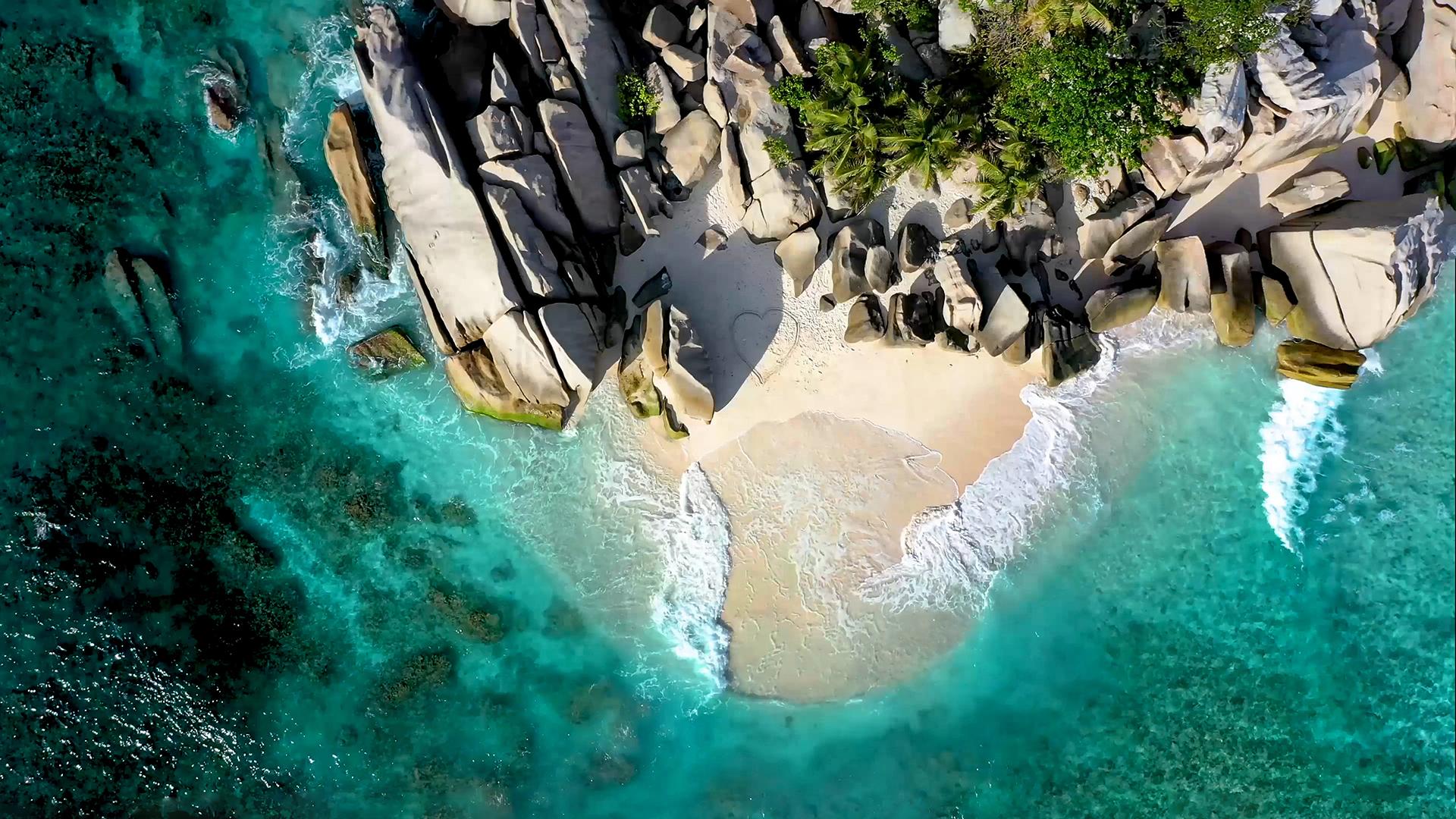 Drawing a large heart figure on the sand of a seashore