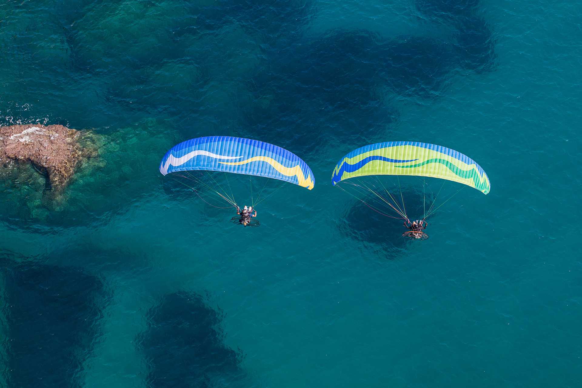 Skydivers fly over water