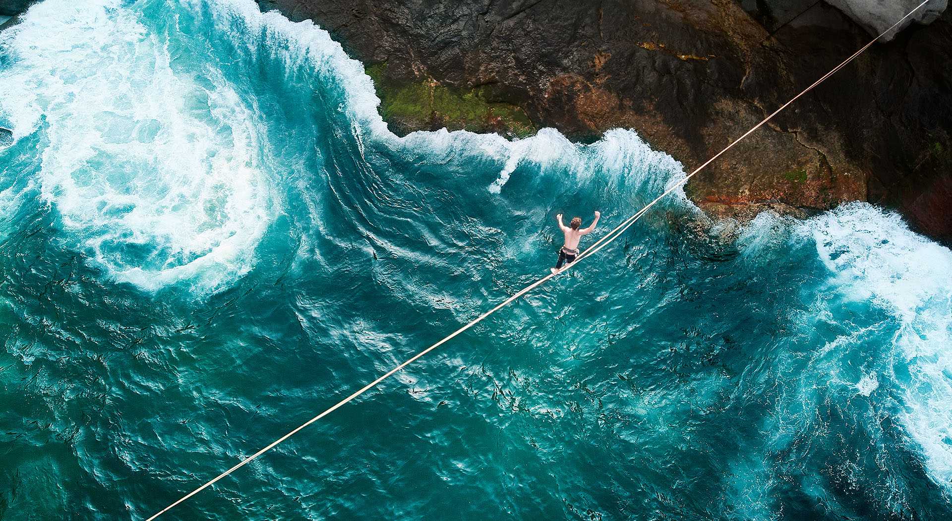 Slackliner überquert einen wilden Fluss